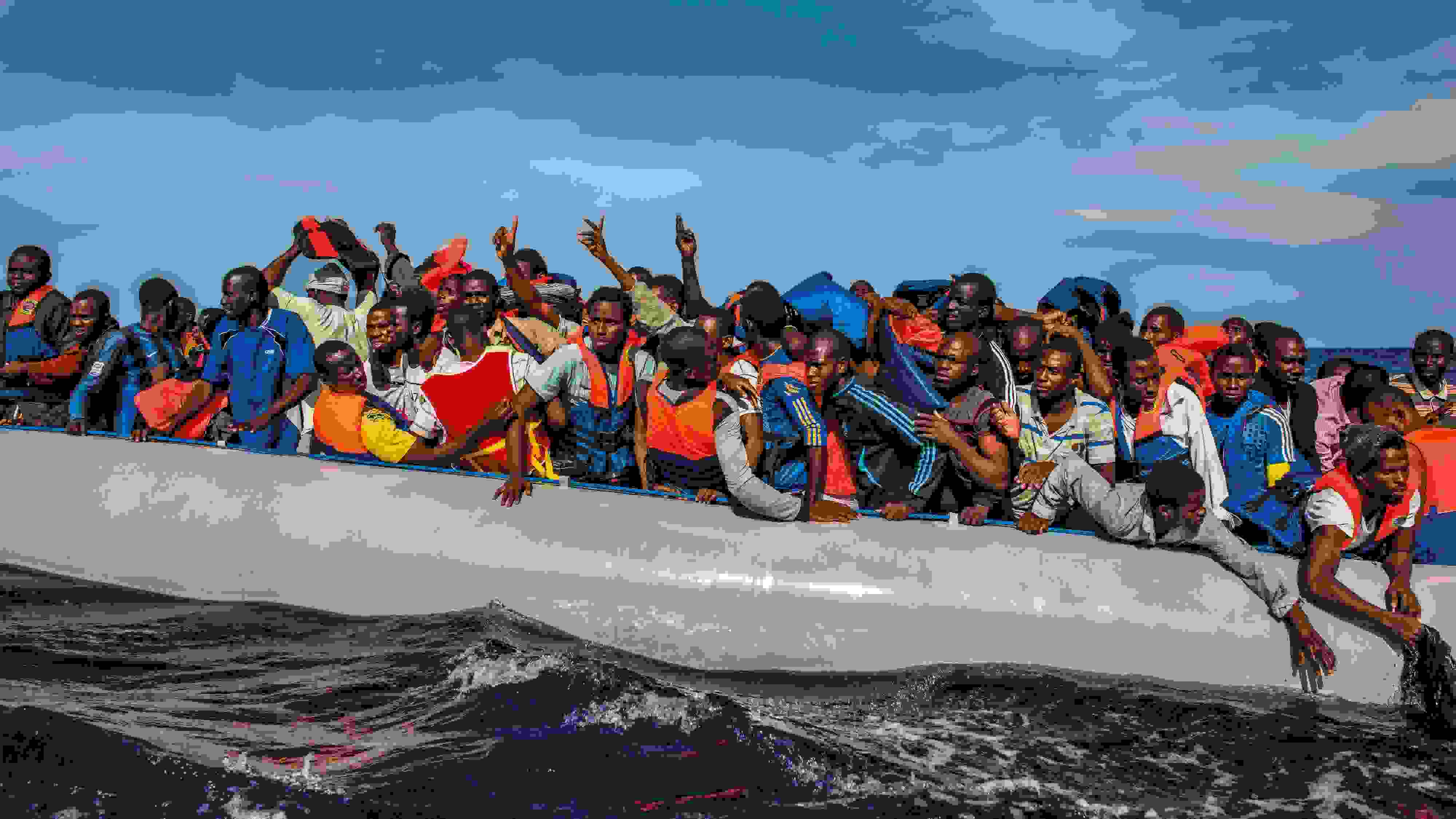 One hundred and nine African refugees from Gambia, Mali, Senegal, Ivory Coast, Guinea, and Nigeria are rescued by the Italian navy from a rubber boat in the sea between Italy and Libya, October 2014.