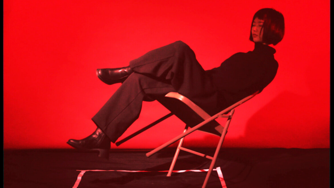 person on a reclining balancing chair in red light 