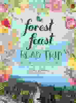 A book cover featuring an image of a lake surrounded by evergreens, all framed by watercolored flowers and fruits. In the center, the title reads, "The Forest Feast: Road Trip".