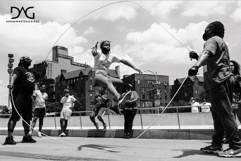 A girl jumping rope while people watch 