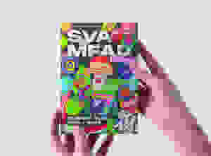 A pair of hands holds up a book cover featuring a colorful array of stickers and "SVA MFAD" in bold font.