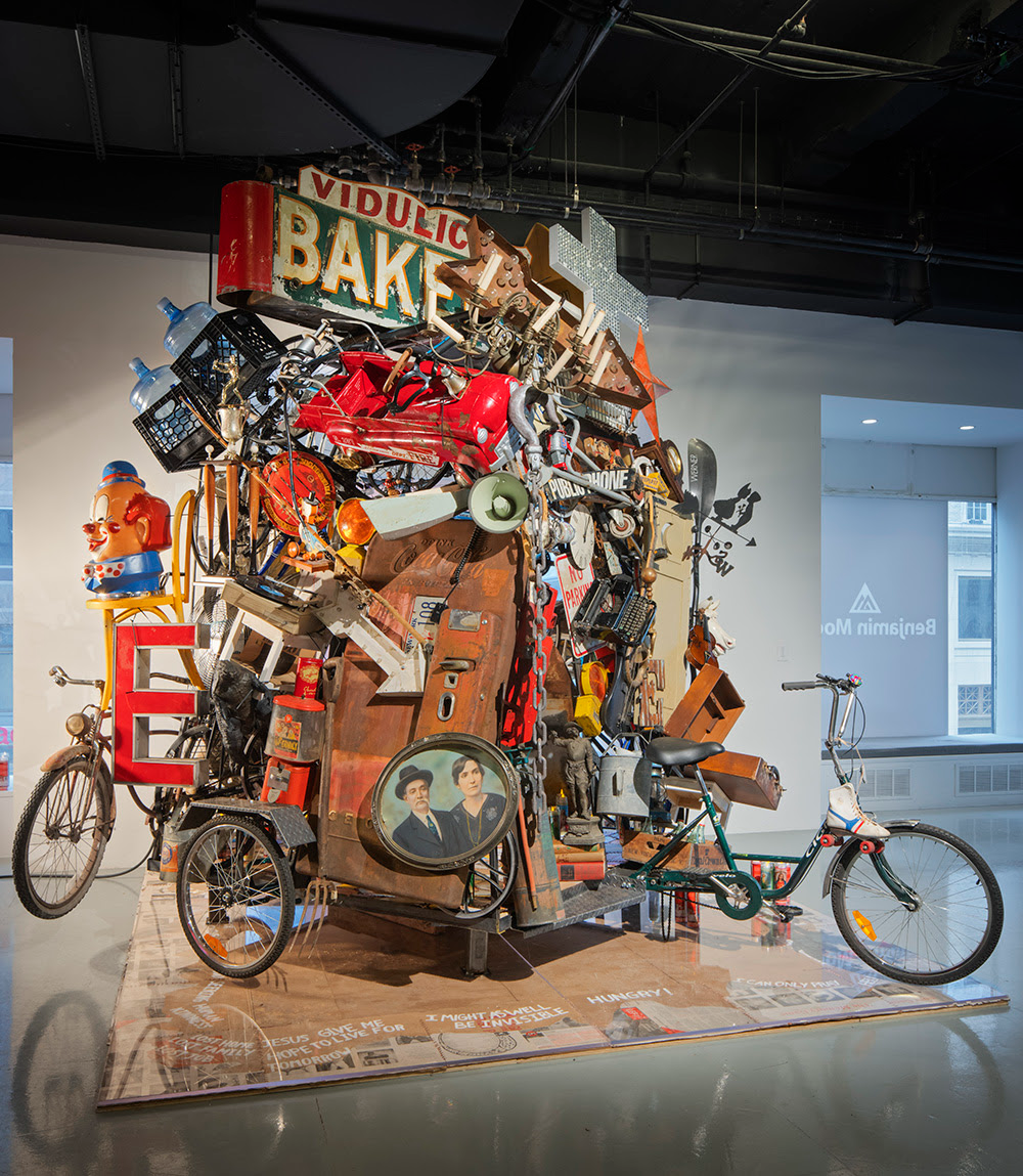 An installation of various objects and trash, from bikes to old signage, constructed to make a large vessel.