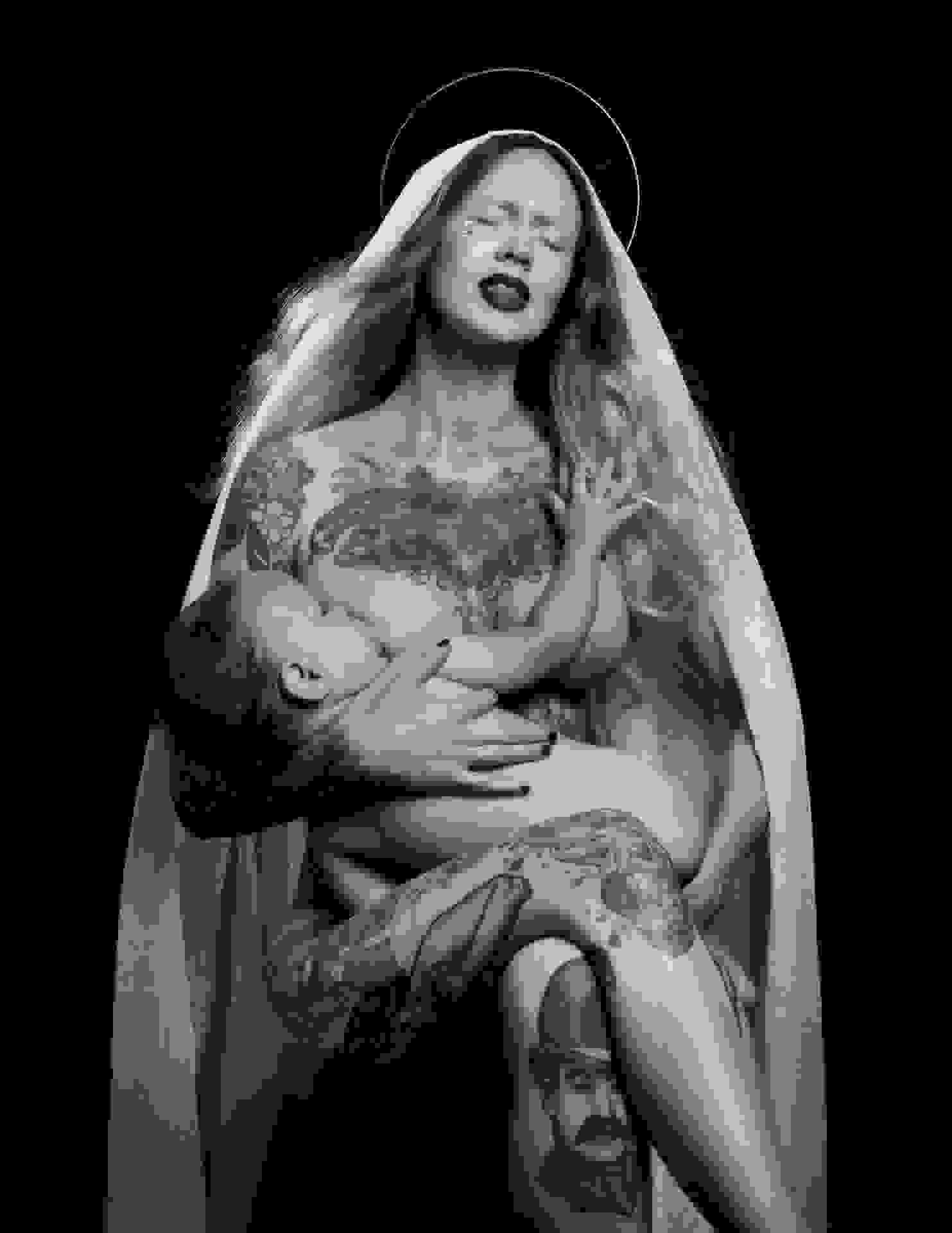 A photograph of a tattooed woman wearing a halo and breastfeeding a baby.